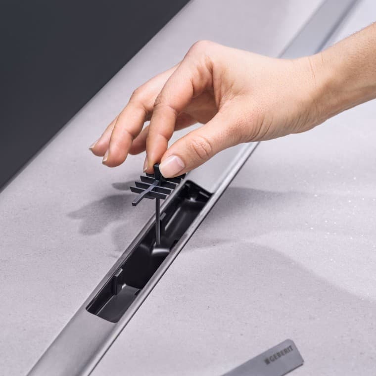 Kézzel fésűbetét elhelyezése a lefolyóban Kézzel fésűbetét elhelyezése a lefolyóban