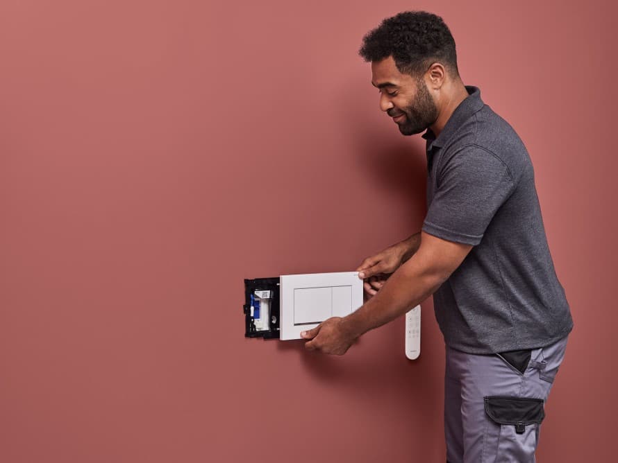 Egy férfi a Geberit DuoFresh szagelszívó beszerelését végzi Egy férfi a Geberit DuoFresh szagelszívó beszerelését végzi